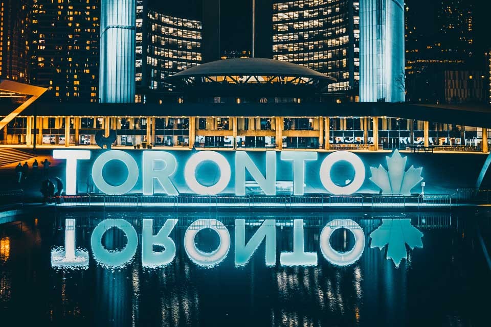 Image of a sign of Toronto lit up at night
