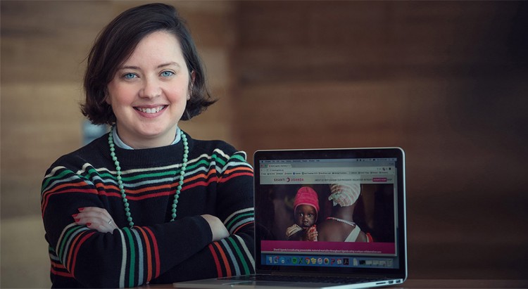 Image of Kate Hyde sitting at a wooden table with a laptop