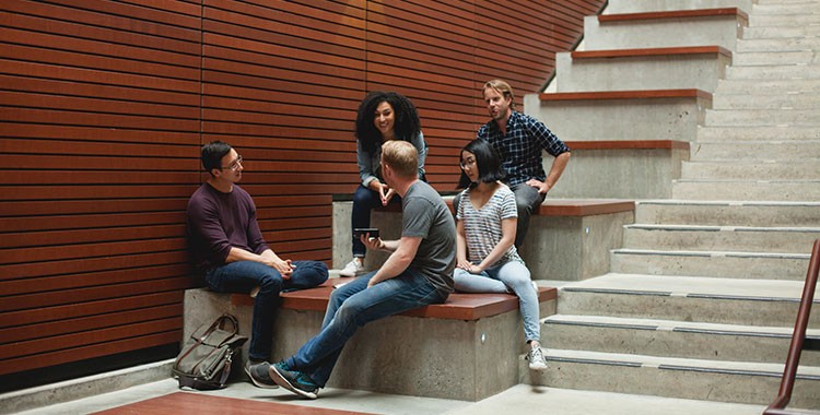 Students sitting on steps inside UBC Sauder Building