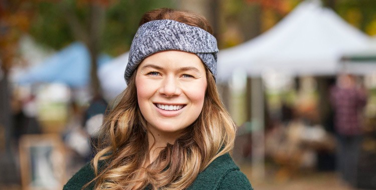 Image of Brianna Brown outside with a market behind her