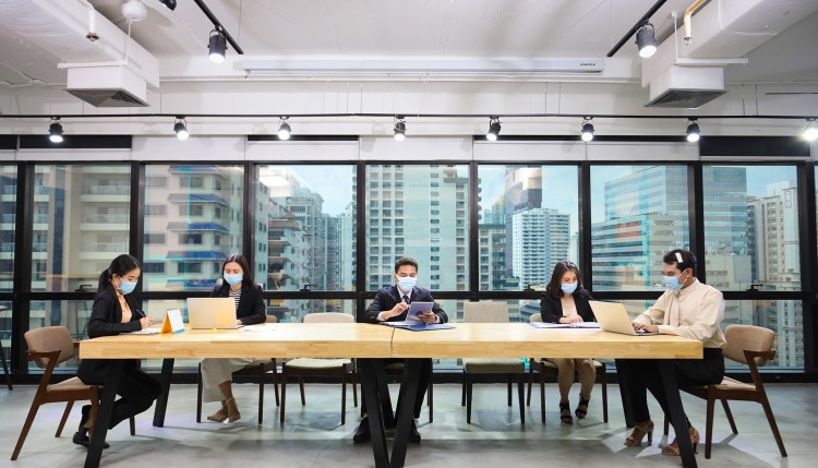 A boardroom with people wearing masks.